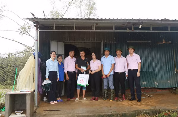 Phó Tổng Giám đốc Lê Thị Đức Hạnh (thứ 4 từ phải qua) động viên, chia sẻ cùng gia đình ông Hoàng Văn Dũng ở thôn Hà Tràng Tây, xã Đông Hải, huyện Tiên Yên thiệt hại bởi cơn bão số 3 làm hư hỏng khu nhà ở, toàn bộ tài sản, khu vực chăn nuôi của gia đình bị nước lũ cuốn trôi.