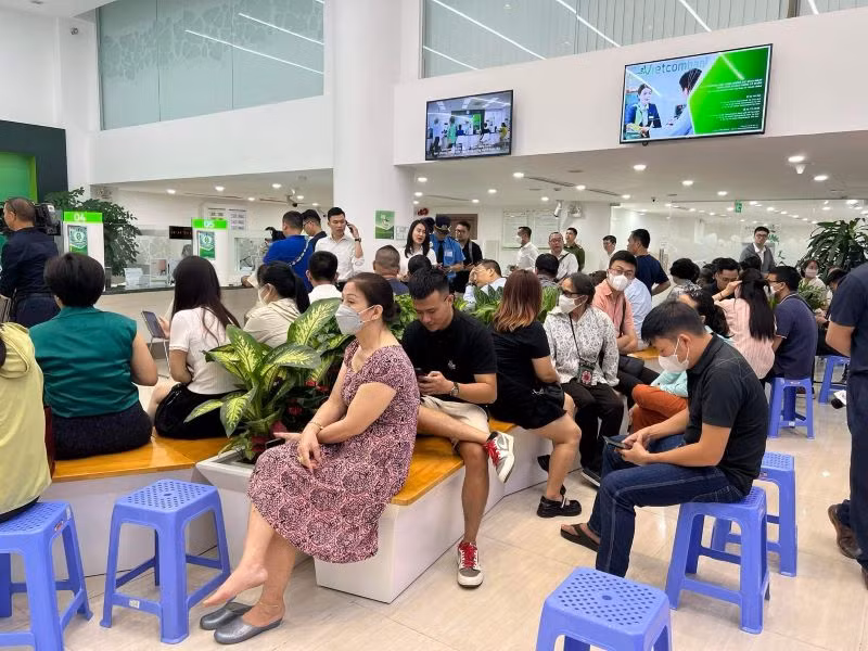 Người dân chờ đến lượt mua vàng tại một điểm giao dịch của Vietcombank. Người dân chờ đến lượt mua vàng tại một điểm giao dịch của Vietcombank.