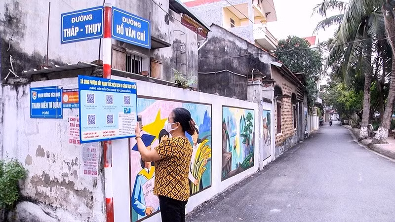 Người dân xã Song Phượng (huyện Ðan Phượng, Hà Nội) quét mã QR tìm hiểu thủ tục hành chính. (Ảnh THẮNG VĂN)