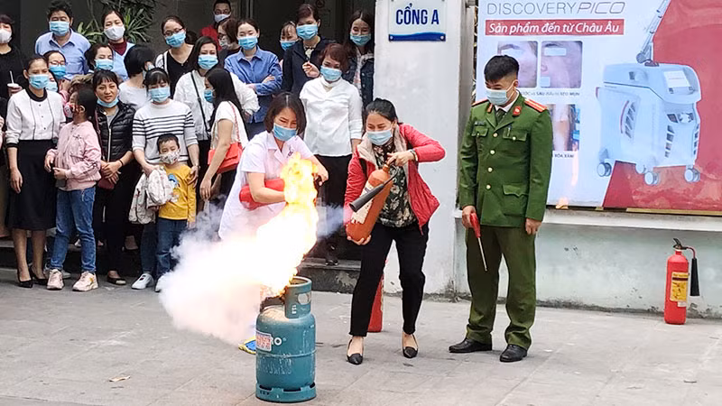Hướng dẫn người dân sử dụng bình bọt chữa cháy an toàn. (Ảnh: KHÁNH AN)