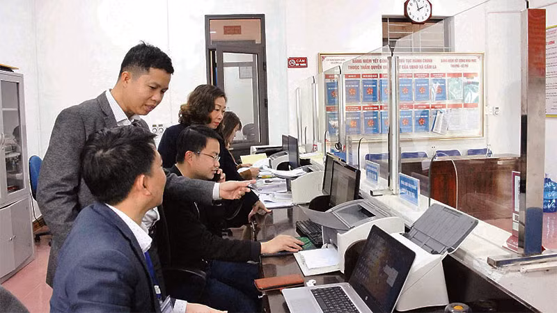 Người dân được cán bộ ở Bộ phận Một cửa của Ủy ban nhân dân xã Cẩm La, thị xã Quảng Yên hướng dẫn làm thủ tục hành chính trực tuyến.
