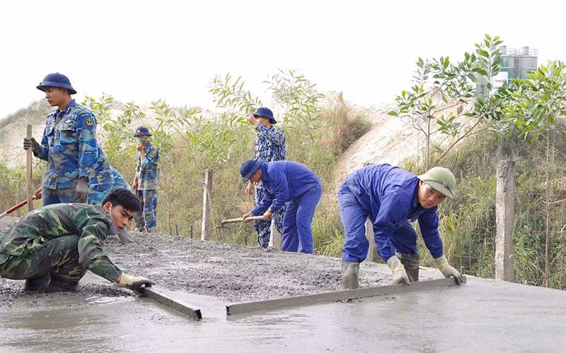 Cán bộ, chiến sĩ Lữ đoàn Công binh 131 (Quân chủng Hải quân) giúp nhân dân phường An Hồng, quận Hồng Bàng, thành phố Hải Phòng rải bê-tông mặt đê hữu sông Cấm.