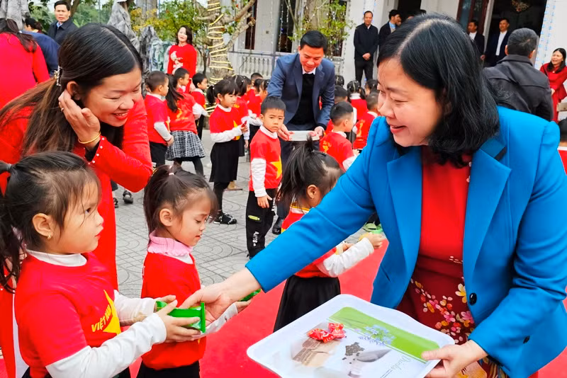 Đồng chí Bùi Thị Minh Hoài và lãnh đạo tỉnh Thanh Hóa phát bánh, kẹo cho trẻ em.