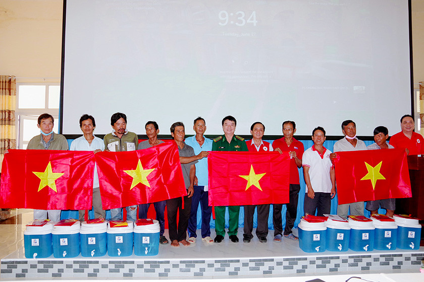 Trao tặng cờ Tổ quốc và bình lọc nước cho ngư dân.