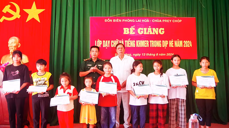 Trao quà và giấy chứng nhận cho các em học sinh.