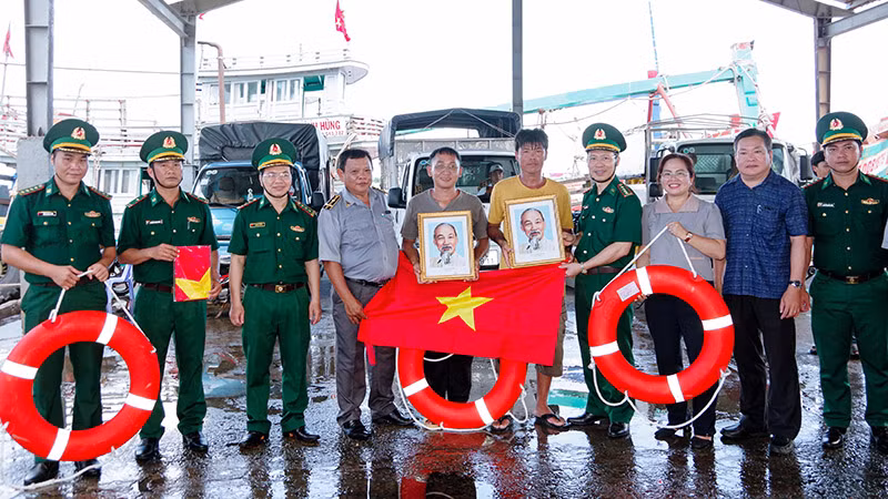 Trao tặng ảnh Bác Hồ, cờ Tổ quốc và phao cứu sinh cho các ngư dân tại cảng cá Trần Đề.