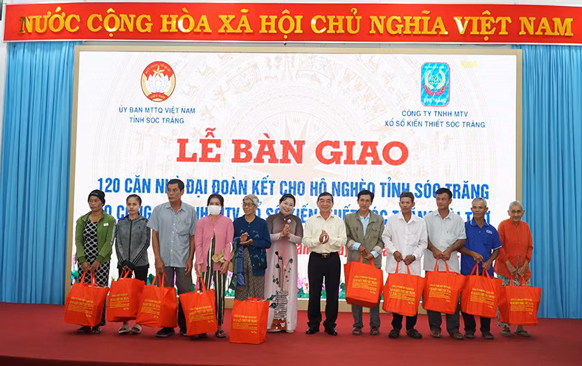 Lãnh đạo tỉnh và Công ty Xổ số Kiến thiết Sóc Trăng tặng quà cho các hộ nghèo được nhận nhà.