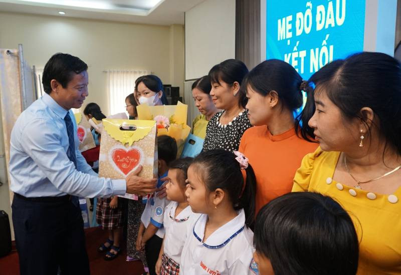 Lãnh đạo Ủy ban nhân dân tỉnh Long An trao hoa cho các mẹ đỡ đầu và quà cho trẻ mồ côi. 