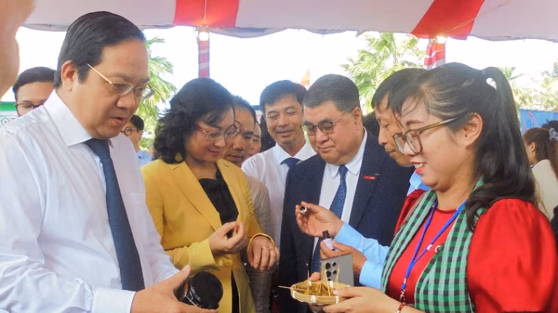 Thứ trưởng Bộ Công thương Phan Thị Thắng (áo vàng) và Lãnh đạo tỉnh Long An tham quan sản phẩm của doanh nghiệp trưng bày tại hội nghị.