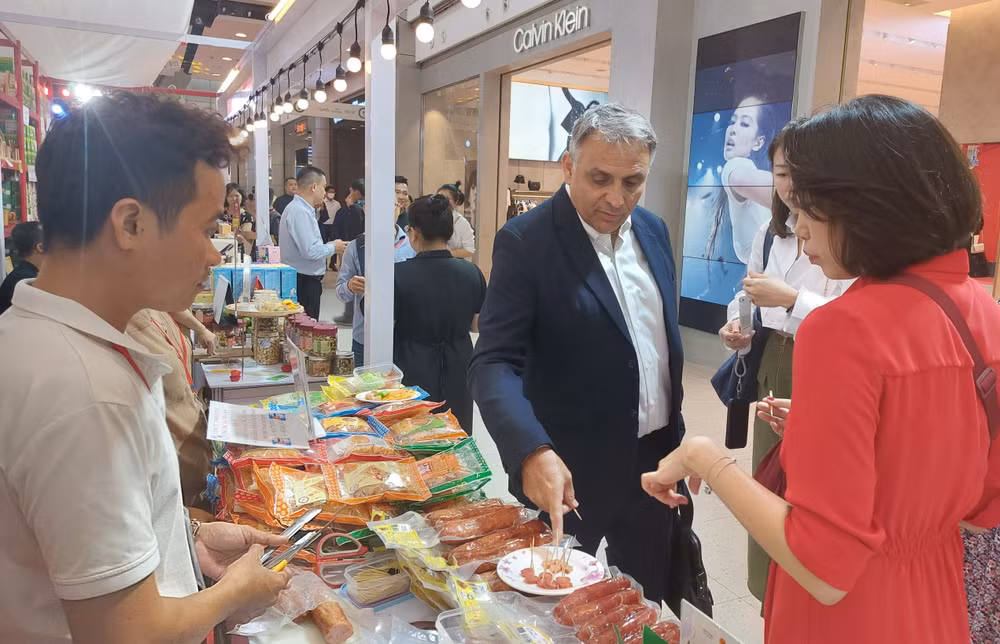 Doanh nhân và khách hàng Thái Lan tìm hiểu sản phẩm lạp xưởng của doanh nghiệp tỉnh Long An sản xuất.