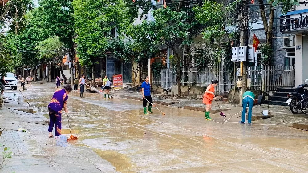 Ngay sau khi nước rút, người dân phường Hồng Hà, thành phố Yên Bái tham gia dọn vệ sinh đường phố. (Ảnh: THANH SƠN)