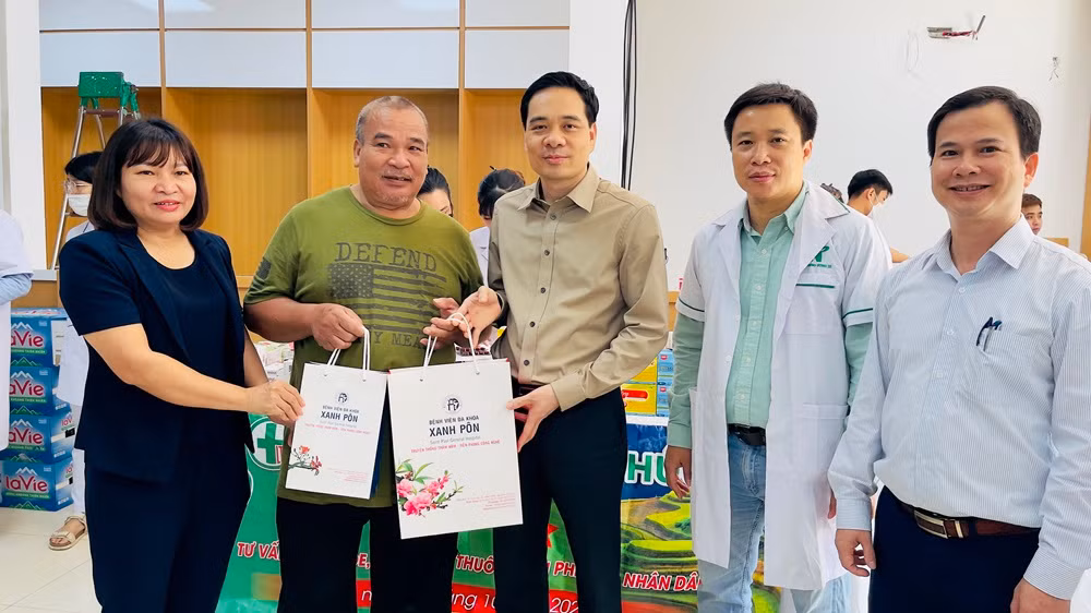 Lãnh đạo Bệnh viện Đa khoa Xanh Pôn cùng Sở Y tế Yên Bái trao quà cho người thành phố Yên Bái. (Ảnh: THANH SƠN)