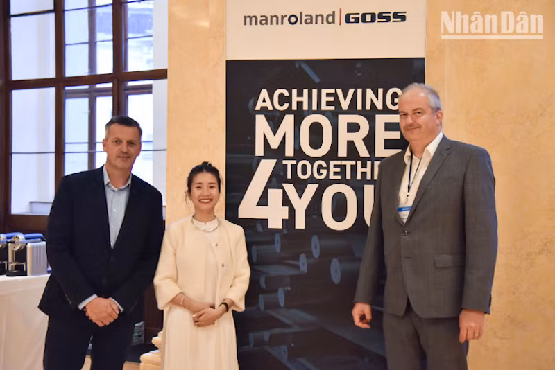 Nhà cung cấp giải pháp in ấn Manroland Goss chúc mừng đại diện Báo Nhân Dân. (Ảnh: MINH DUY)