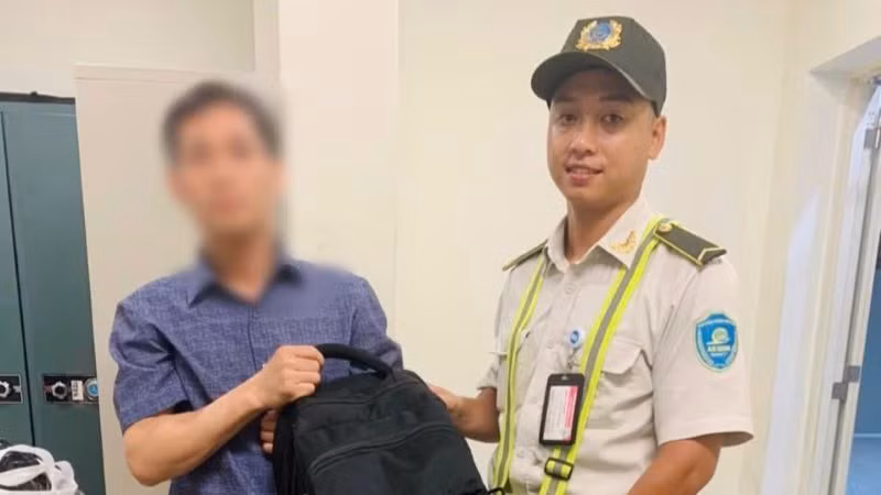 Anh Nguyễn Thanh Bình, nhân viên an ninh Cảng Hàng không quốc tế Nội Bài trao trả chiếc ba lô cho chủ nhân.