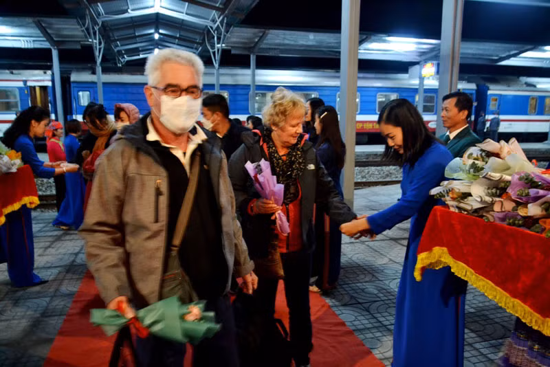 Buộc chỉ cổ tay và tặng hoa cho du khách chúc mừng năm mới thành công.