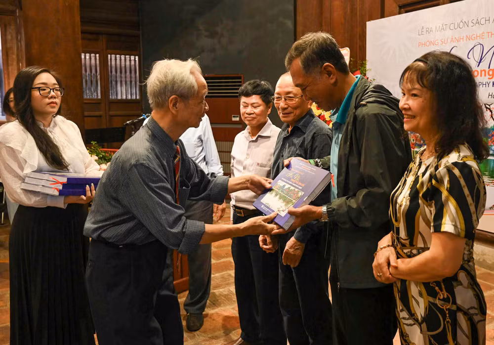 Nghệ sĩ nhiếp ảnh Nguyễn Văn Phúc trao tặng sách cho các đại biểu. (Ảnh: DUY LINH). Nghệ sĩ nhiếp ảnh Nguyễn Văn Phúc trao tặng sách cho các đại biểu. (Ảnh: DUY LINH).