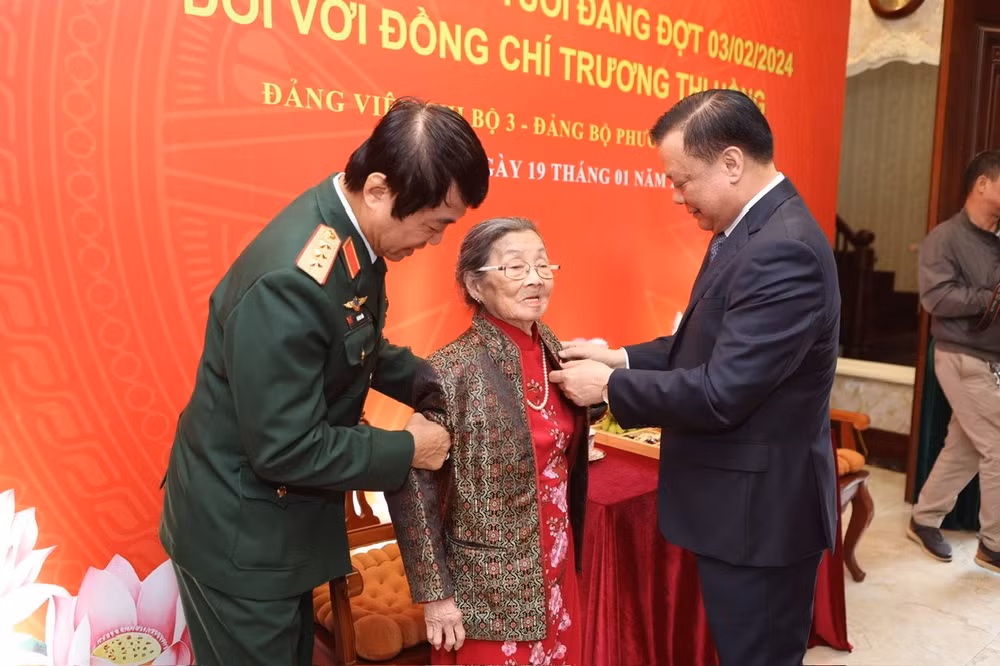 Bí thư Thành ủy Hà Nội Đinh Tiến Dũng trao Huy hiệu cho đảng viên lão thành.