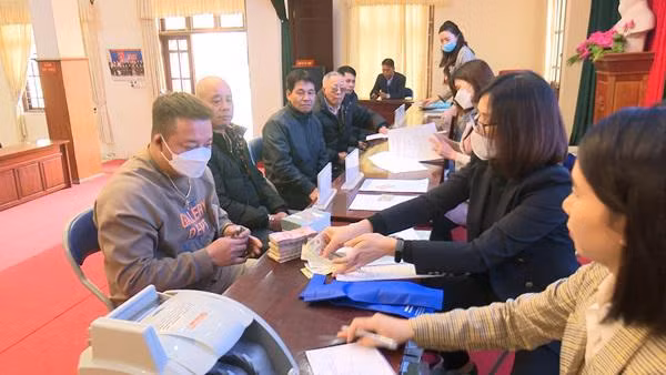 Người dân xã Minh Khai, huyện Hoài Đức (Hà Nội) nhận tiền hỗ trợ giải phóng mặt bằng dự án đường Vành đai 4-Vùng Thủ đô.