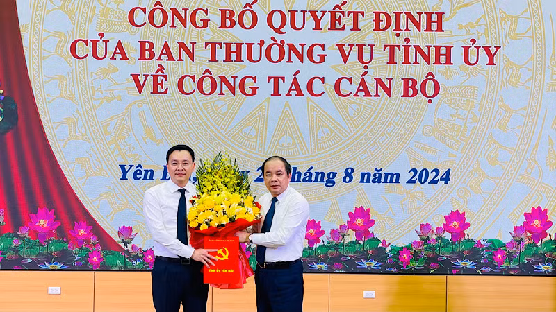 Đồng chí Tạ Văn Long, Phó Bí thư Thường trực Tỉnh ủy tặng hoa Chánh Văn phòng Tỉnh ủy An Hoàng Linh. (Ảnh: THANH SƠN)