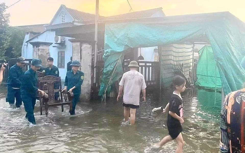 Dân quân huyện Yên Bình giúp dân di chuyển vật dụng gia đình chạy lũ.(Ảnh:THANH SƠN)