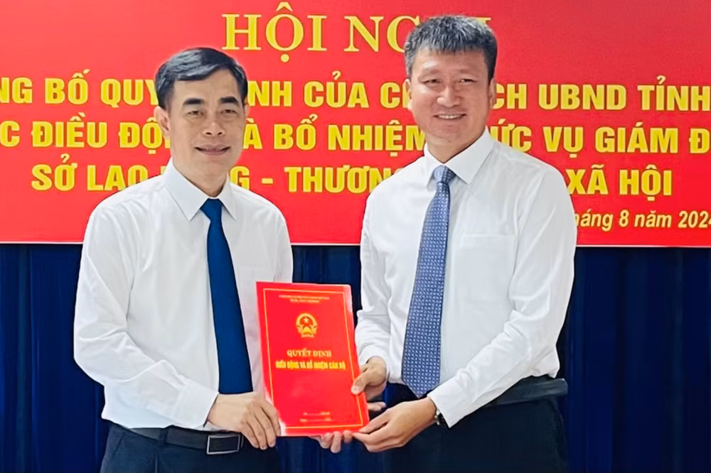 Chủ tịch Ủy ban nhân dân tỉnh Trần Huy Tuấn (bên phải) trao quyết định Giám đốc Sở Lao động-Thương binh và xã hội đối với đồng chí Đỗ Quang Minh. (Ảnh: THANH SƠN)