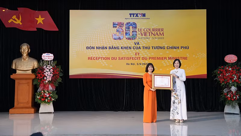 Tổng Giám đốc Vũ Việt Trang đã trao Bằng khen của Thủ tướng Chính phủ tặng Báo Le Courrier du Vietnam. (Ảnh: TTXVN)