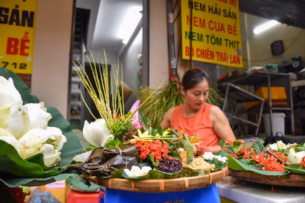Những cửa hàng bán hoa, đồ trang trí mâm Tết Đoan Ngọ cũng rất đông khách. Đa phần, những mâm hoa quả được khách hàng đặt làm từ trước rồi hôm nay mới đến lấy.