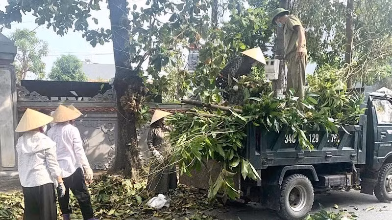 Lực lượng chức năng thu gom cành cây gãy đổ trên các tuyến phố đưa về nơi xử lý.