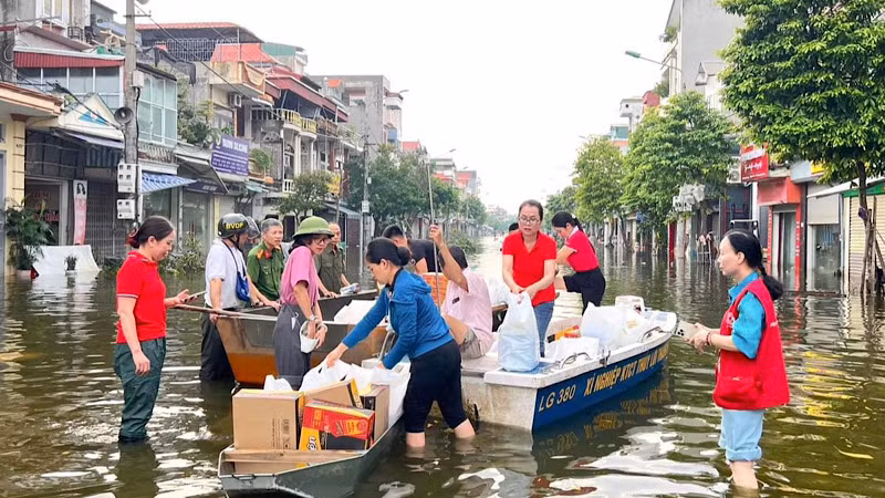 Cán bộ thành phố mang quà hỗ trợ các khu dân cư còn trong diện ngập úng.