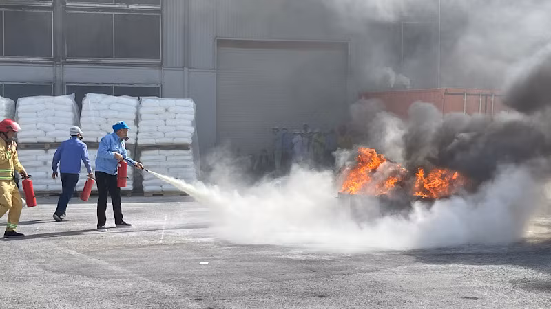 Công nhân Công ty cổ phần Nhựa An Phát Xanh chữa cháy bằng bình chữa cháy nhỏ.