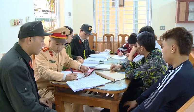 Công an làm việc với các thanh niên có hành vi vi phạm khi tham gia giao thông đường bộ.