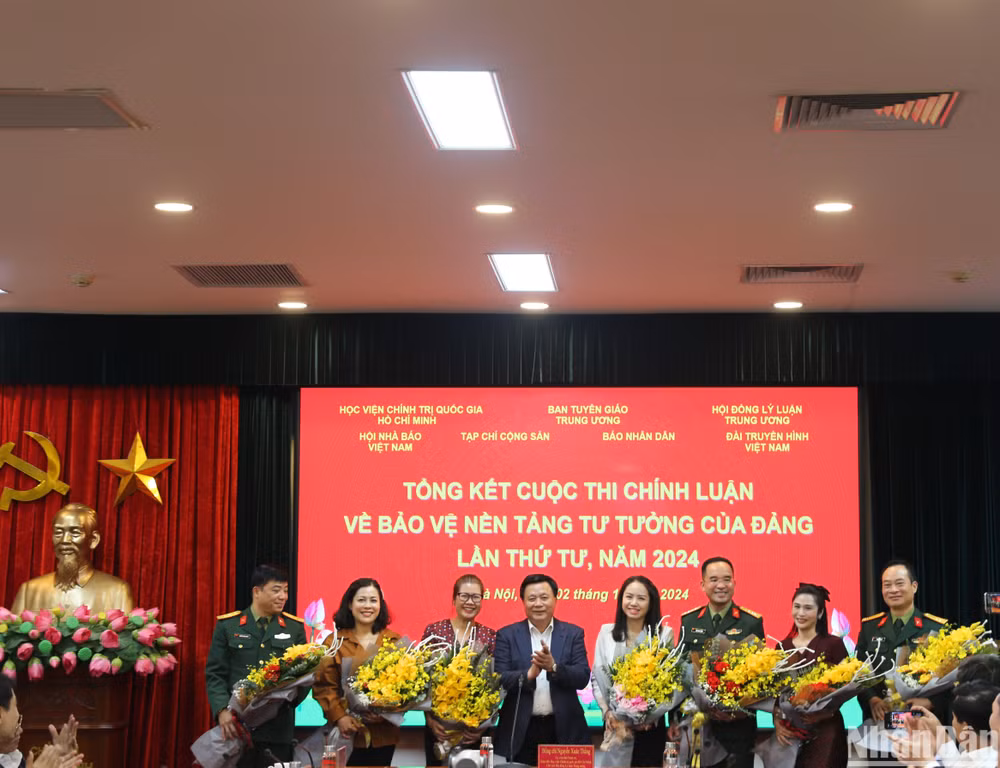 Đồng chí Nguyễn Xuân Thắng tặng hoa cho các đơn vị phối hợp tổ chức Lễ trao giải. (Ảnh: HẢI ĐĂNG)