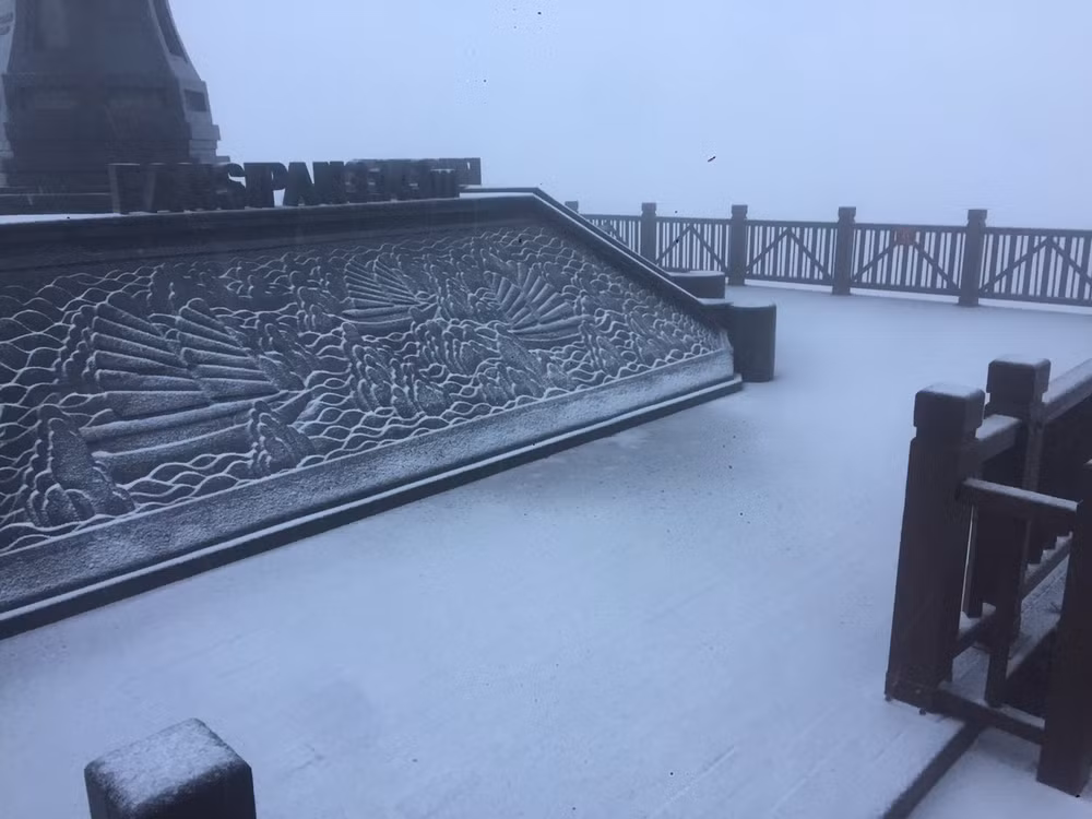 Tuyết xuất hiện trắng xóa tại chân cột cờ trên đỉnh Fansipan.