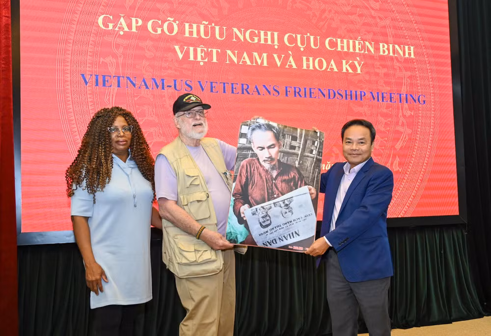 Phó Tổng Biên tập Báo Nhân Dân Đinh Như Hoan trao quà lưu niệm tặng ông Steve Edmunds và phu nhân. (Ảnh Duy Linh)