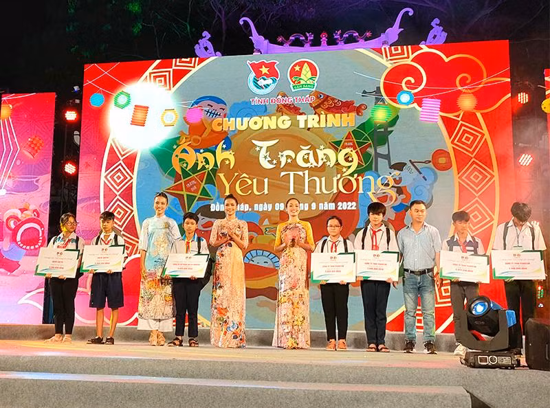 Đại biểu tham dự trao sổ tiết kiệm cho thiếu nhi bị ảnh hưởng bởi dịch bệnh Covid-19 (Ảnh: HỮU NGHĨA)