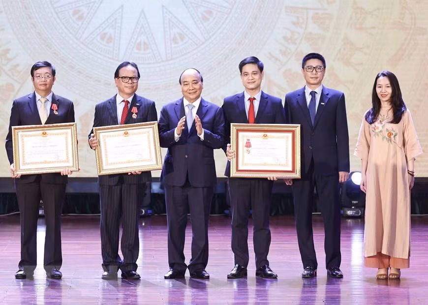 Chủ tịch nước Nguyễn Xuân Phúc trao tặng Huân chương Lao động hạng Ba cho tập thể và các cá nhân Trường đại học Kinh tế quốc dân. (Ảnh: Thống Nhất/TTXVN)