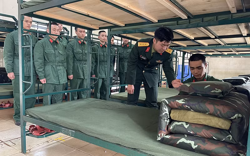 Chỉ huy Đại đội 8, Tiểu đoàn 2, Trung đoàn 2, Sư đoàn 395 (Quân khu 3) hướng dẫn chiến sĩ mới cách gấp chăn, màn.