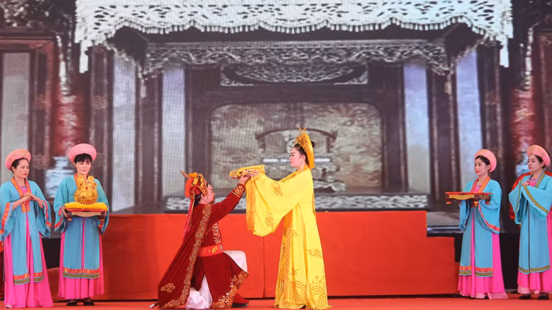 Các nghệ sĩ tái hiện cảnh Thái hậu Dương Vân Nga trao áo hoàng bào cho tướng quân Lê Hoàn cầm quân chống giặc ngoại xâm.