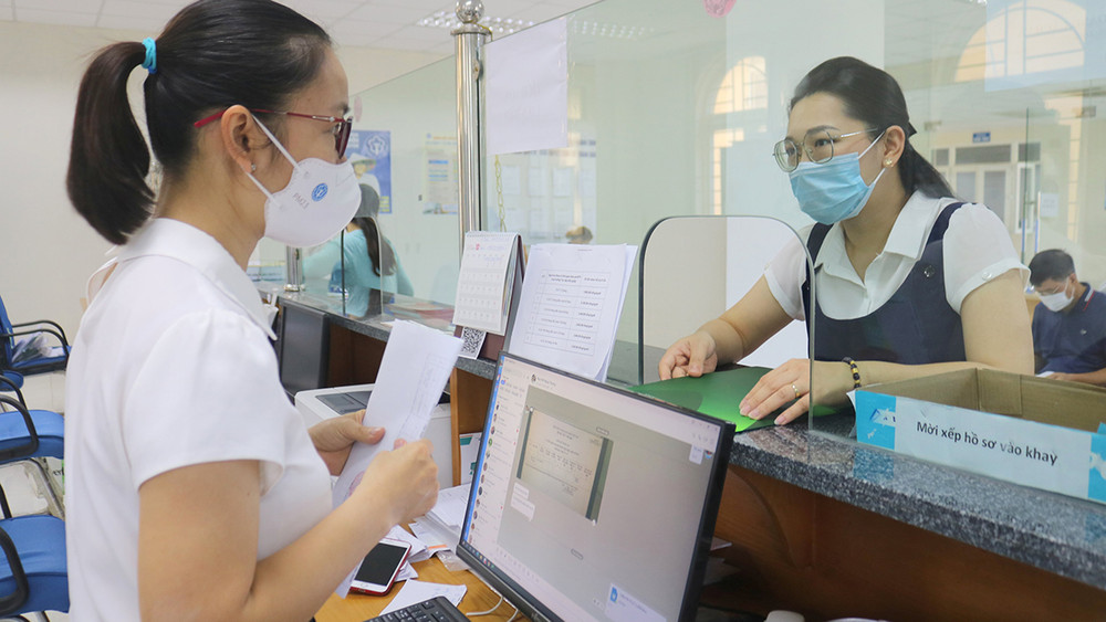 Cán bộ Bảo hiểm xã hội tỉnh hướng dẫn chi trả chế độ cho người lao động. 