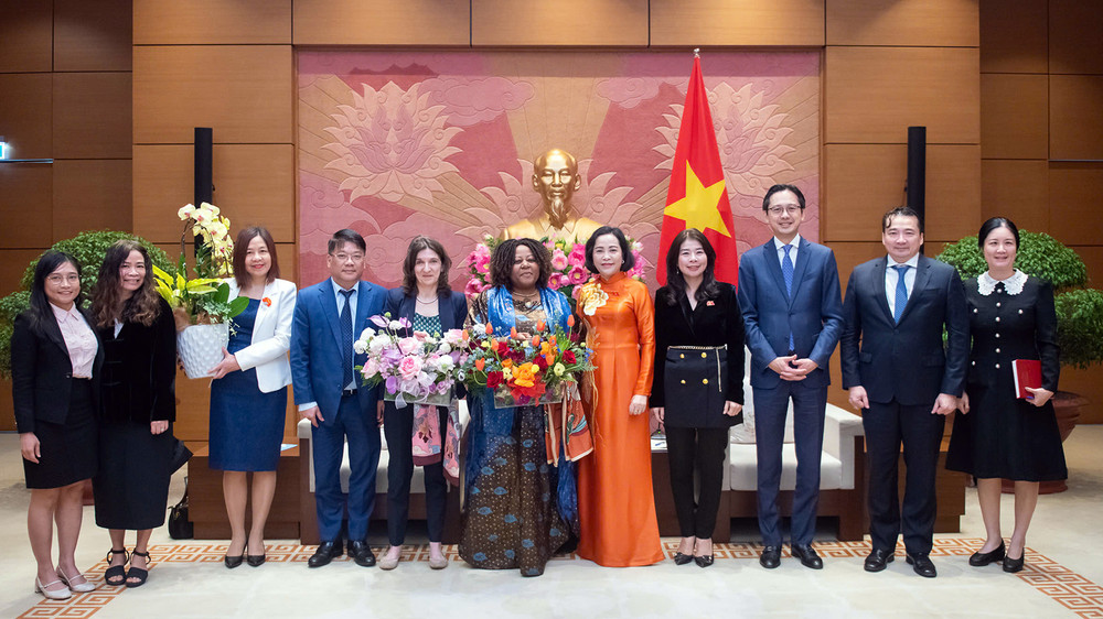 Phó Chủ tịch Quốc hội Nguyễn Thị Thanh (thứ 5 từ phải sang) trao hoa tặng bà Caroline Nyamayemombe và bà Michaela Bauer (lần lượt thứ 6 và 7 từ phải sang) cùng đại diện các cơ quan liên quan tại buổi tiếp.