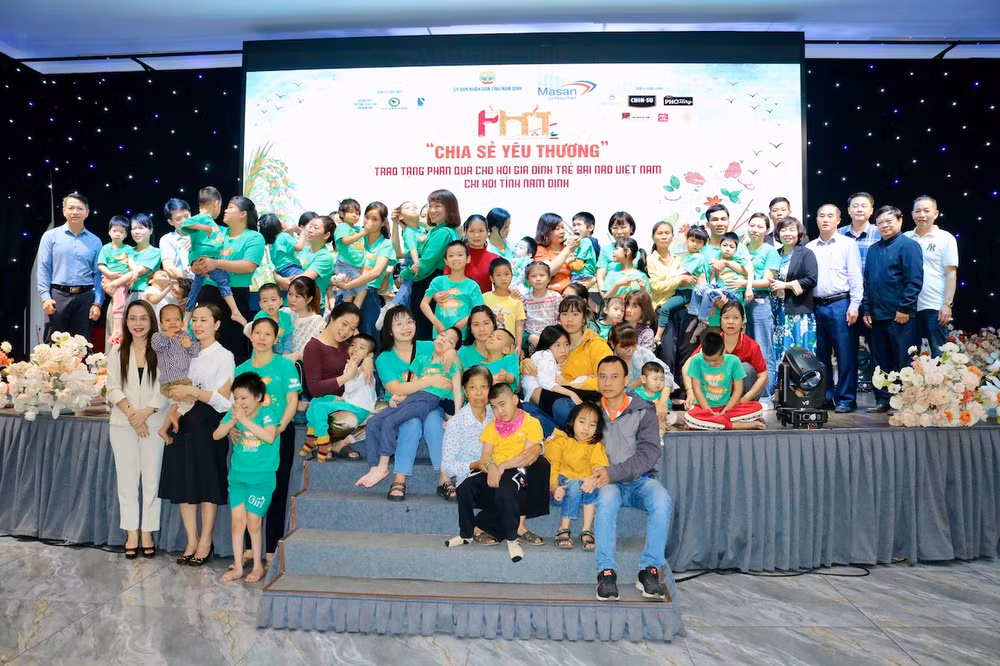 Các đại biểu và các gia đình trẻ bại não được "chia sẻ yêu thương" chụp ảnh lưu niệm tại chương trình.
