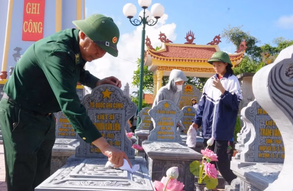 Các đoàn thể chính trị xã hội chăm sóc phần mộ liệt sĩ tại Nghĩa trang Liệt sĩ xã Hải Triều, huyện Hải Hậu (Nam Định).