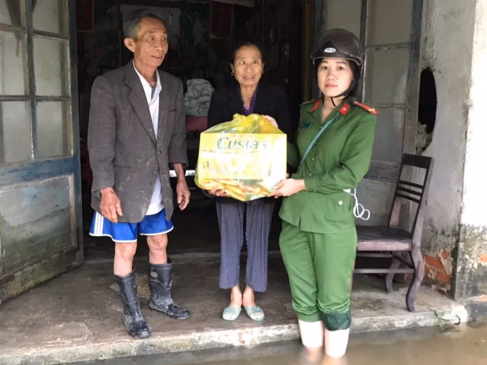 Thượng úy Phan Thị Thủy trao quà cho người dân xã Thạch Hội trong đợt lũ lịch sử năm 2020. (Ảnh: Nhân vật cung cấp)