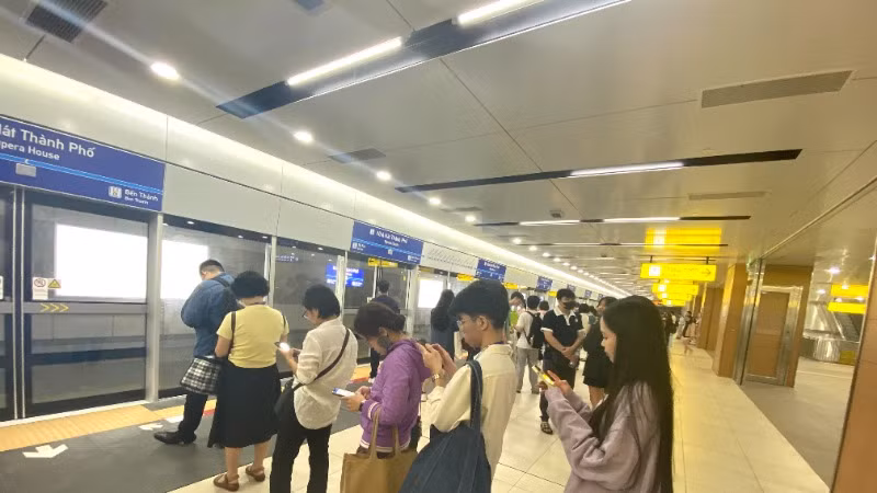 Hành khách xếp hàng chờ tàu Metro số 1 ở nhà ga. (Ảnh: QUÝ HIỀN)