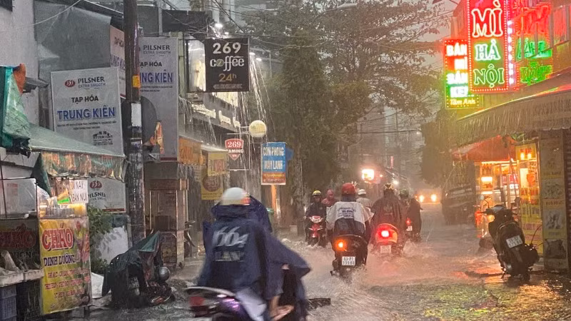 Người dân lưu thông trong cơn mưa lớn sáng sớm ngày 10/5 khu vực đường Nguyễn Văn Quá, quận 12. (Ảnh: QUÝ HIỀN)