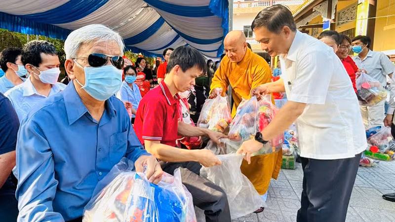 Đồng chí Nguyễn Văn Lộc, Chủ tịch Hội đồng nhân dân tỉnh, Trưởng Ban Dân vận Tỉnh ủy, Chủ tịch Ủy ban Mặt trận Tổ quốc Việt Nam tỉnh Bình Dương và Hòa thượng Thích Huệ Thông trao tặng quà cho người khiếm thị tại phiên chợ.