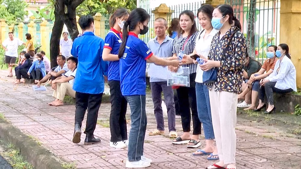 Các tình nguyện viên phát nước nước miễn phí cho người nhà thí sinh.