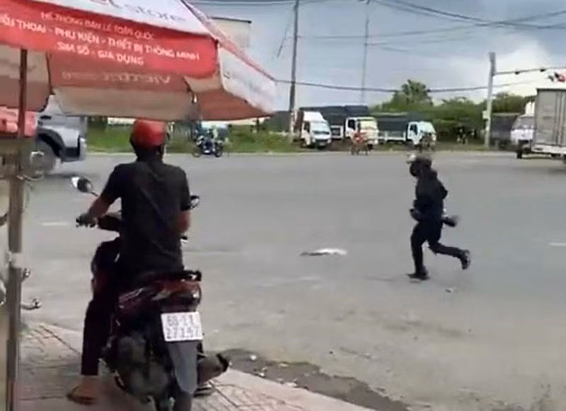Đối tượng cướp từ phòng giao dịch ngân hàng chạy ra hướng Quốc lộ 51. (Ảnh cắt từ clip)