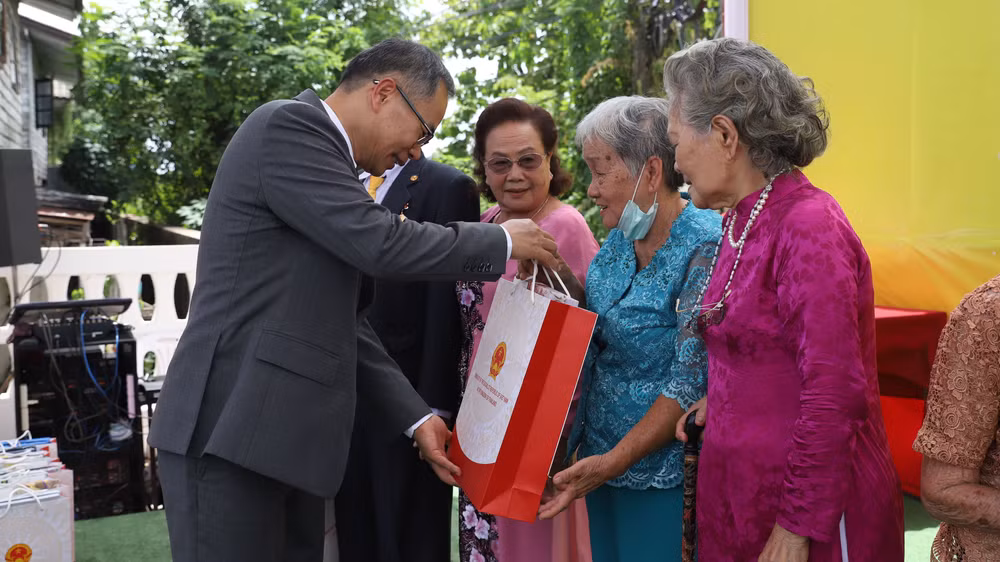 Đại sứ Phan Chí Thành tặng quà cho các kiều bào lão thành.
