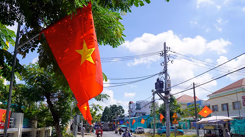 Đường Lê Văn Lương, huyện Nhà Bè thêm sinh động khi được treo cờ đỏ sao vàng dọc hai bên đường để chào đón Tết Độc lập.